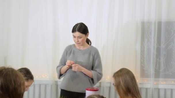 Girls at the lesson with the teacher sew a soft toy with their own hands — Stock Video