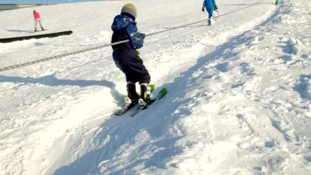 视频的雪滑雪斜坡, 升降机线和山谷的公园在瓦萨奇。阳光明媚的一天, 家人在滑雪板和滑雪板。五颜六色的冬天暖和的衣服。往下看斜坡度假村. — 图库视频影像
