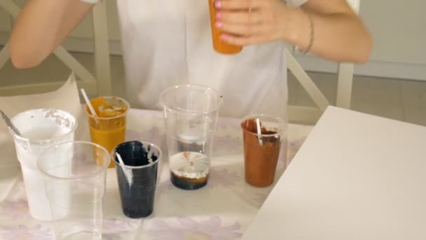 Woman prepares and paints paints for drawing a picture of fluid art — Stock Video