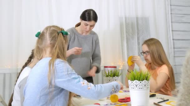 Дівчата на уроці з вчителем шиють м'яку іграшку своїми руками — стокове відео