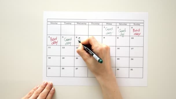 Signez le jour dans le calendrier avec un stylo, dessinez une bonne mauvaise journée — Video