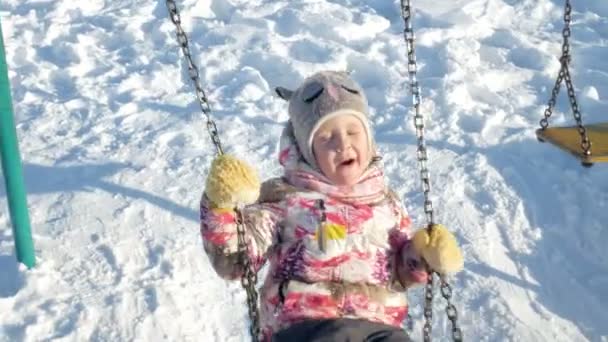 En invierno chica parque en un columpio — Vídeos de Stock