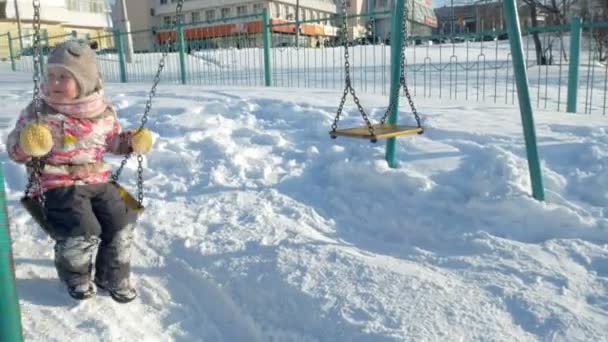 Στο χειμερινό πάρκο κορίτσι σε μια κούνια — Αρχείο Βίντεο