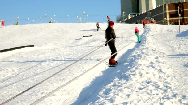 Video ze sněhu lyžařské svahy, výtah čar a valley Park v Wasatch. Slunečný den s rodinou na lyže a snowboardy. Barevné zimní teplé oblečení. Při pohledu dolů sklon uchylovat. — Stock video
