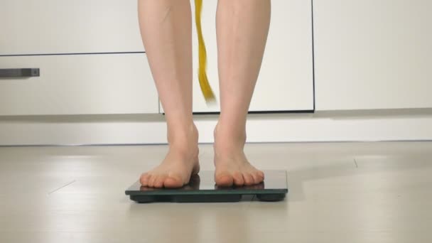 Женщина стоя на весах на полу — стоковое видео