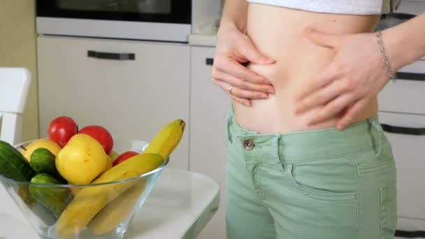 Mujer delgada medir la cintura en el fondo de un plato con frutas y verduras, un estilo de vida saludable — Vídeos de Stock