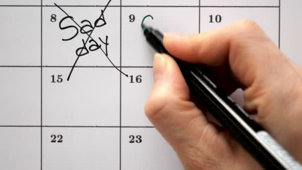 Meld u de dag in de kalender met een pen, trekken van een trieste dag — Stockvideo
