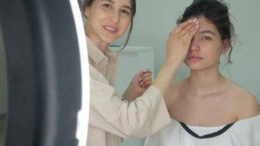 Makyaj sanatçısı tarafından makyaj yapan güzel bir kadın.