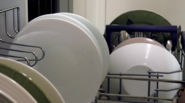 Genç bir kadın temiz bir tabak bir bulaşık bırakır.