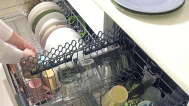 Genç bir kadın temiz bir tabak bir bulaşık bırakır.