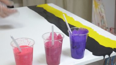 kadın bir resim sanat sıvı tuval üzerine çizer.