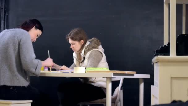 Due donne adulte dipingono con vernici acriliche colorate in una scuola d'arte — Video Stock