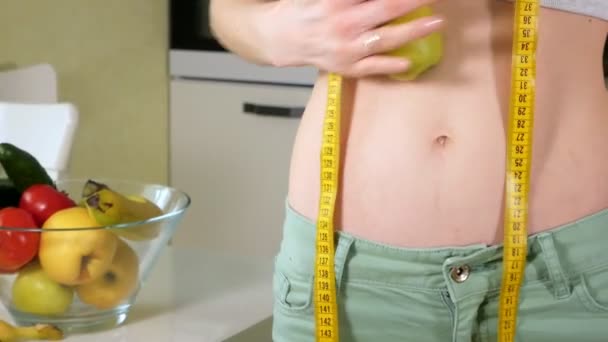 Slanke vrouw houd maatregel op de achtergrond van een bord met fruit en groenten, een gezonde levensstijl — Stockvideo