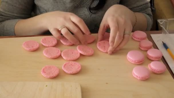 Šéfkuchař si o macaron, mezi nimiž je krém. Kuchař dělá krásné zákusky s jejich vlastních rukou. — Stock video