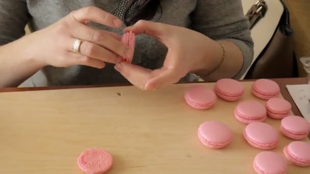 Šéfkuchař si o macaron, mezi nimiž je krém. Kuchař dělá krásné zákusky s jejich vlastních rukou. — Stock video