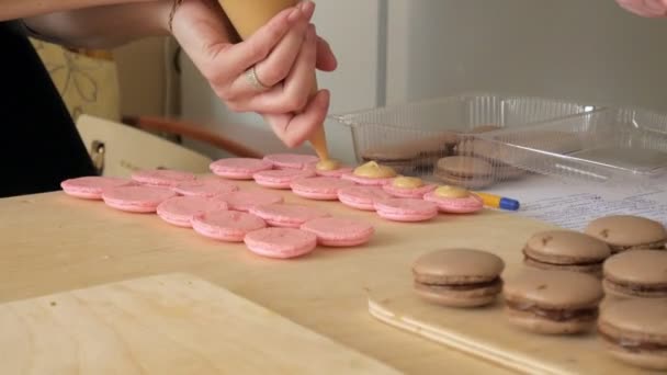 Şef aralarında bir krem olduğunu bir macaron olun. Cook güzel tatlılar, kendi elleri ile yapar. — Stok video