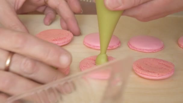 Kocken gör av en macaron mellan vilka är en kräm. Cook gör vackra desserter med sina egna händer. — Stockvideo