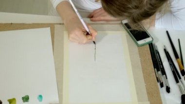 küçük güzel kızıl saçlı kız masadan boya ile boyar