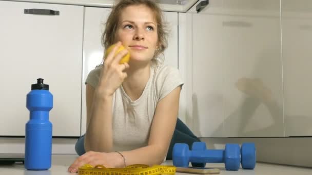Etkin atletik sportif kadın spor kıyafeti yeme elma eğitimden sonra havlu ile — Stok video