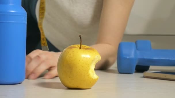 Mujer deportiva atlética activa con toalla en traje deportivo comiendo manzana después del entrenamiento — Vídeo de stock