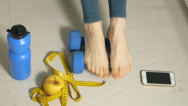 Slanke vrouw houd maatregel op de achtergrond van een bord met fruit en groenten, een gezonde levensstijl — Stockvideo