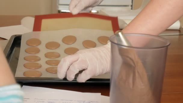 Chef faz de um macaron entre o qual é um creme. Cook faz belas sobremesas com suas próprias mãos . — Vídeo de Stock