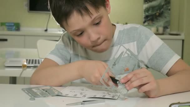 Chłopak tworzy plastikowy model samolotu, dokładna kopia, od projektanta — Wideo stockowe