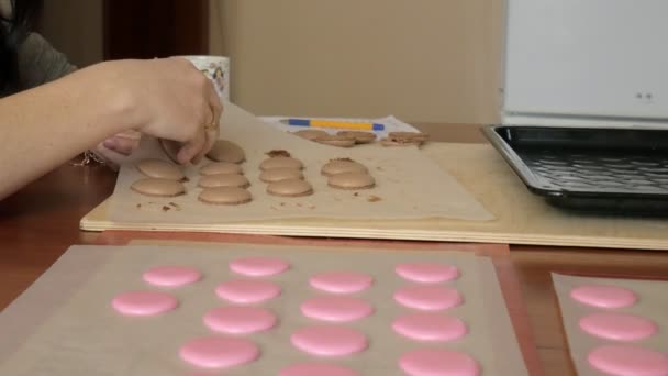 Šéfkuchař si o macaron, mezi nimiž je krém. Kuchař dělá krásné zákusky s jejich vlastních rukou. — Stock video