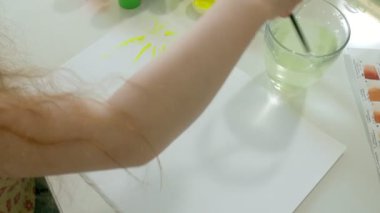 küçük güzel kızıl saçlı kız masada oturan paintand fırça ile boya