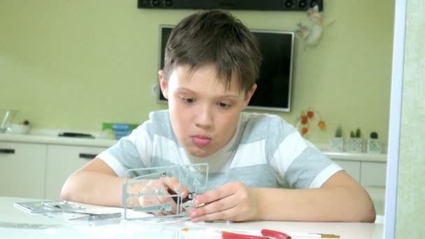 A fiú egy műanyag modell repülőgép, egy pontos másolatot hoz létre a tervező — Stock videók