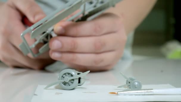 O menino cria um avião modelo de plástico, uma cópia exata, do designer — Vídeo de Stock