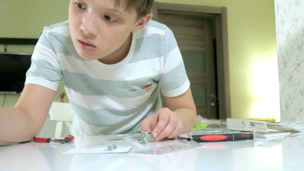 Το αγόρι δημιουργεί ένα πλαστικό μοντέλο αεροπλάνο, ένα ακριβές αντίγραφο, από τον σχεδιαστή — Αρχείο Βίντεο