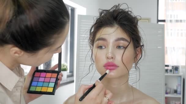 Ung vacker kvinna tillämpa make-up av make-up artist — Stockvideo