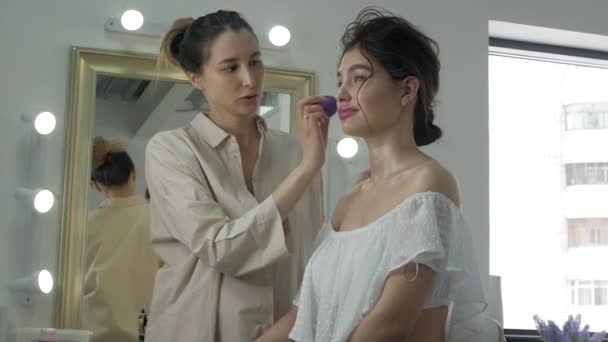 Young beautiful woman applying make-up by make-up artist — Stock Video