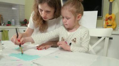 Anne ve çocuk renkli fırça ile boya. Oyunlar çocuklu erken çocukların gelişimini etkiler.