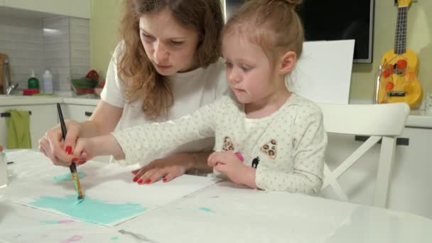 Moeder en kind tekenen met gekleurde kwast. Spelen met kinderen van invloed zijn op de ontwikkeling van jonge kinderen. — Stockvideo