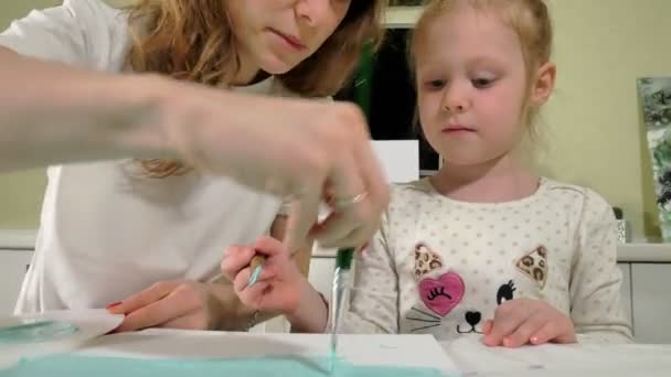 Moeder en kind verf met gekleurde vingers. Spelen met kinderen van invloed zijn op de ontwikkeling van jonge kinderen. — Stockvideo