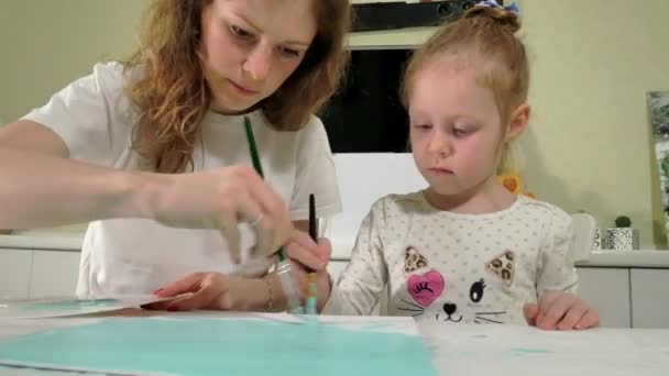 Mother and child paint with colored brush. Games with children affect the development of early children. — Stock Video