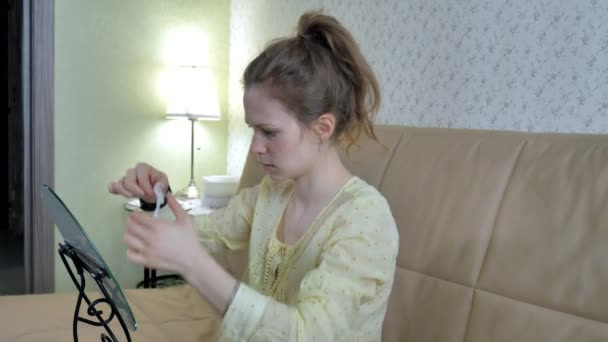 Mujer joven haciendo máscara facial con máscara de limpieza en la cara en la cocina en casa — Vídeos de Stock
