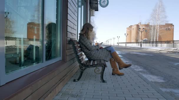 Mulher usando Smartphone Relaxa no banco em Beautiful Park. Jovem mulher em fazer gestos na tela do telefone. Tecnologia ao ar livre — Vídeo de Stock