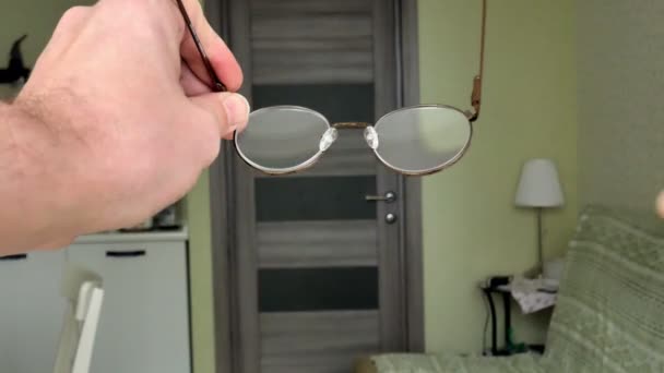 Een man reinigt zijn bril met een servet, een first-person view — Stockvideo