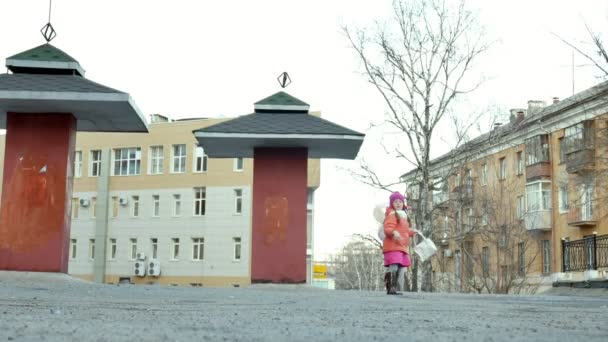 Lilla vackra flicka hoppa på vattenpölar efter regn med färgglada ballonger — Stockvideo