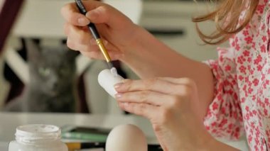 Bir kadın bir ahşap bebek renkli boyalar ile ev stüdyosunda, boyalar Matryoshka boyama, yakın çekim