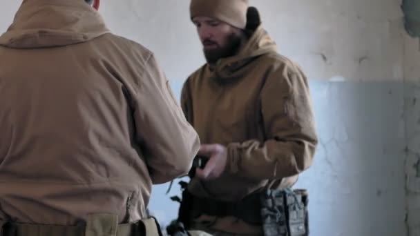 Солдаты в камуфляже готовятся к бою и проверяют снаряжение и оружие — стоковое видео