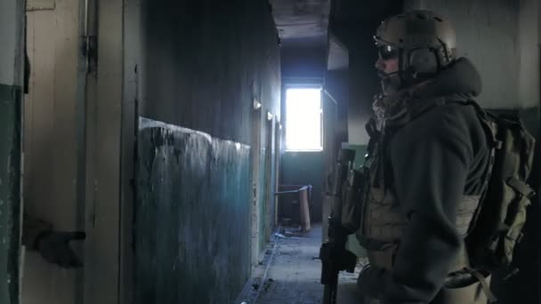Soldiers in camouflage with combat weapons sneak along the corridors of the old building, the military concept — Stock Video