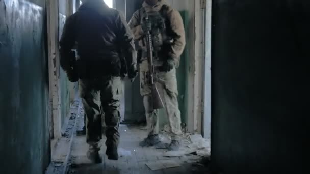 Soldaten in camouflage met bestrijding wapens sluipen langs de gangen van het oude gebouw, het militaire concept — Stockvideo