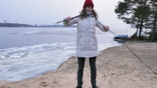 Attraktive junge Touristin mit rotem Hut sammelt ein Touristenzelt am Waldrand an der Küste — Stockvideo