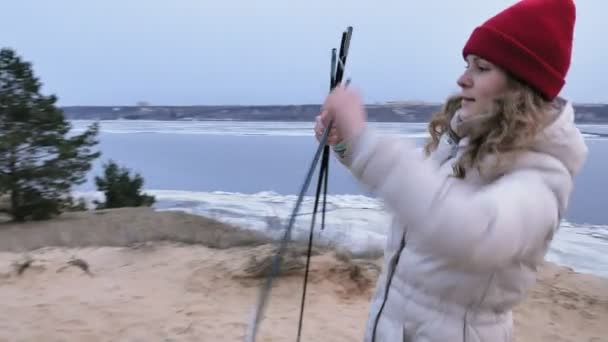 Attrayant jeune femme touristique dans un chapeau rouge recueille une tente touristique près de la forêt sur la côte — Video