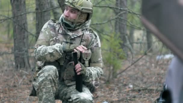 Солдати в камуфляжі готуються до бою і перевіряють обладнання та зброю — стокове відео