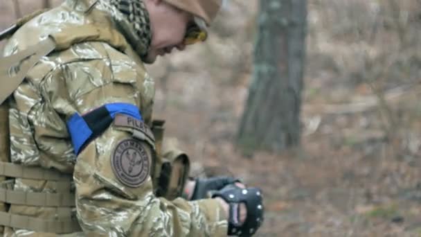 Soldaten in Tarnkleidung bereiten sich auf den Kampf vor und prüfen Ausrüstung und Waffen — Stockvideo